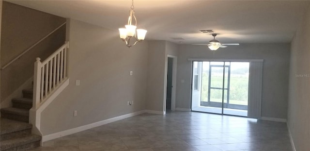 empty room featuring ceiling fan with notable chandelier and tile patterned floors