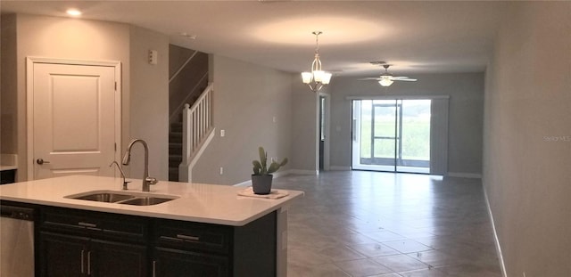 kitchen with decorative light fixtures, a kitchen island with sink, stainless steel dishwasher, sink, and ceiling fan