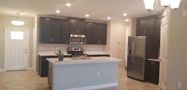 kitchen with pendant lighting, light tile patterned floors, stainless steel appliances, an island with sink, and sink