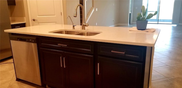 kitchen with light tile patterned flooring, stainless steel dishwasher, sink, and a center island with sink