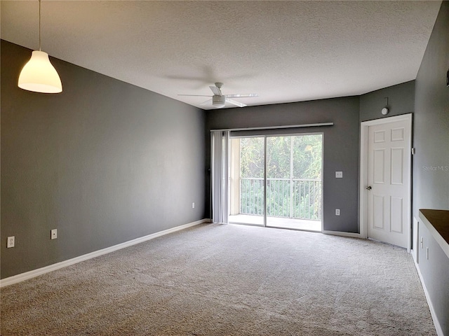 empty room with carpet flooring, ceiling fan, and a textured ceiling