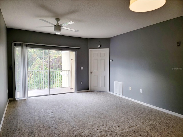 carpeted empty room featuring a textured ceiling and ceiling fan