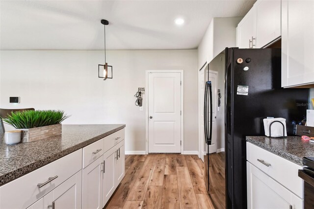 kitchen featuring light wood-type flooring, white cabinets, and hanging light fixtures