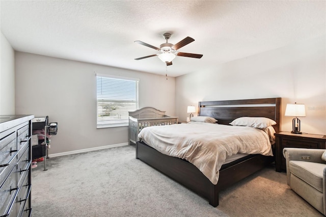 carpeted bedroom with a textured ceiling and ceiling fan