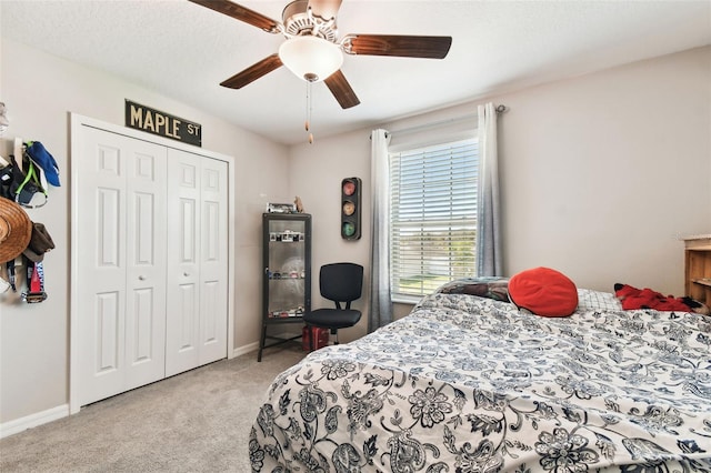 bedroom featuring light carpet, a textured ceiling, ceiling fan, and a closet