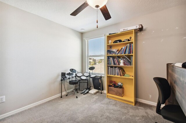 carpeted office with a textured ceiling and ceiling fan