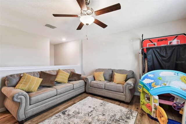 living room featuring hardwood / wood-style floors and ceiling fan