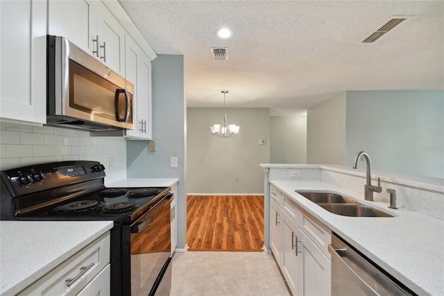 kitchen featuring tasteful backsplash, visible vents, stainless steel appliances, and a sink