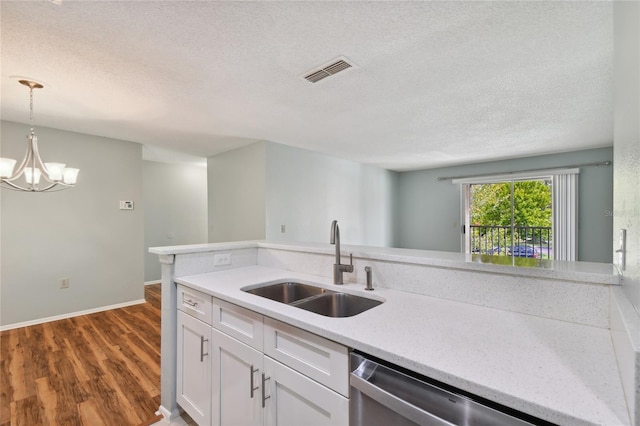 kitchen featuring a sink, visible vents, light countertops, dishwasher, and an inviting chandelier