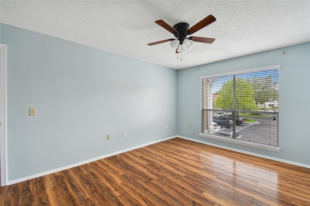 spare room with a textured ceiling, ceiling fan, wood finished floors, and baseboards