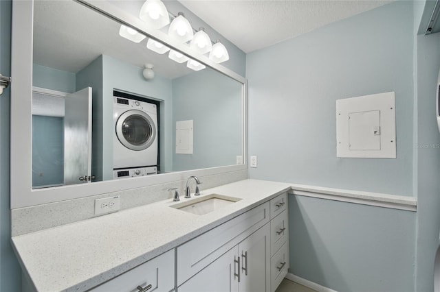 bathroom with stacked washer and dryer, electric panel, a textured ceiling, and vanity