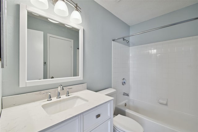 bathroom with a textured ceiling, shower / bathing tub combination, vanity, and toilet