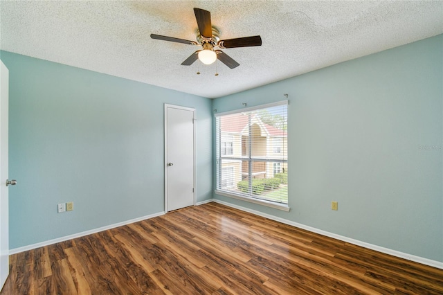 unfurnished room with a textured ceiling, ceiling fan, wood finished floors, and baseboards