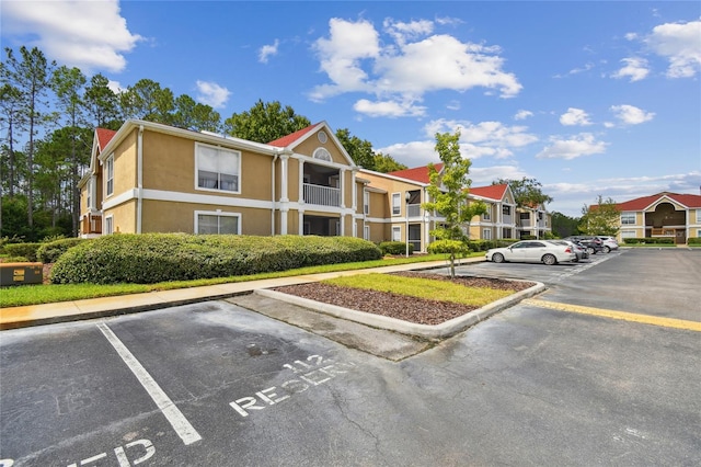 view of building exterior with uncovered parking and a residential view