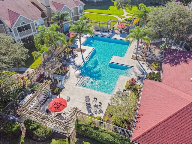 community pool with a patio area and fence