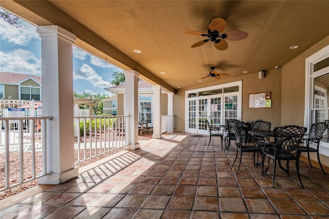 view of patio / terrace with fence, outdoor dining area, a ceiling fan, and french doors