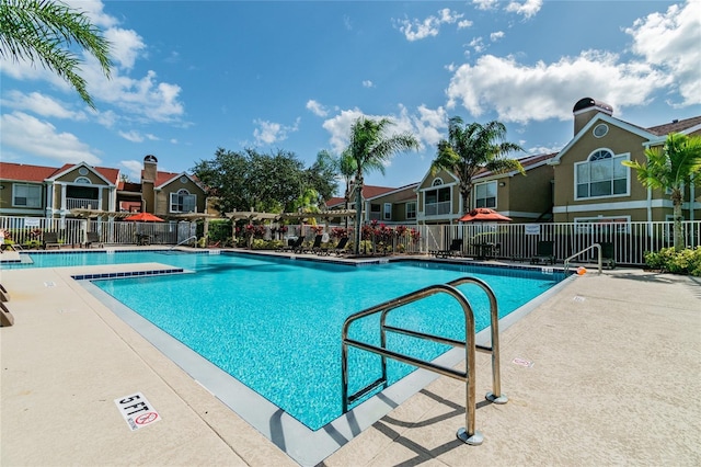 community pool featuring fence and a residential view