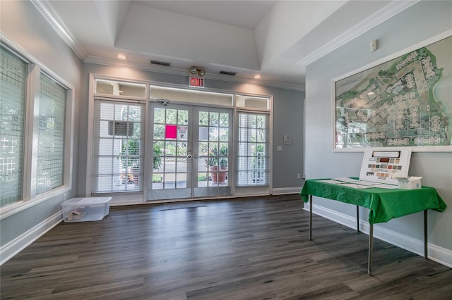 doorway to outside with ornamental molding, a raised ceiling, wood finished floors, and french doors