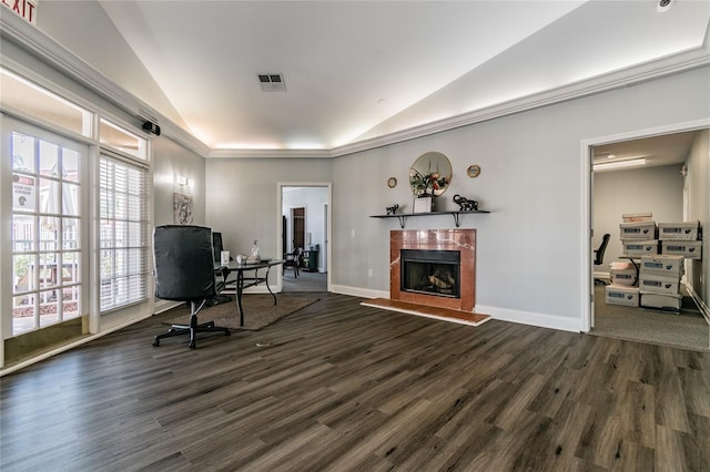 office space featuring dark wood finished floors, lofted ceiling, visible vents, a fireplace with raised hearth, and baseboards