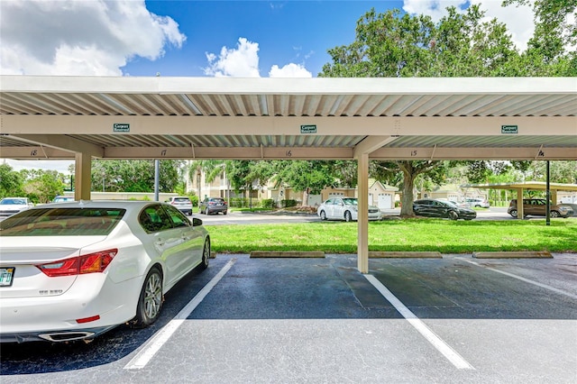 view of vehicle parking with a yard and a carport