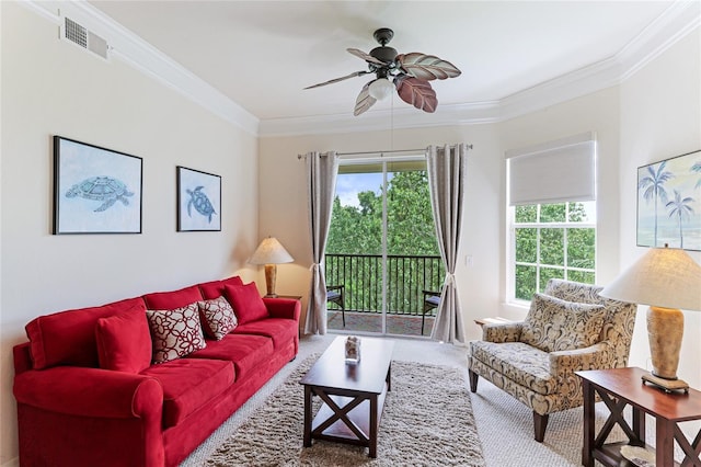 carpeted living area featuring ornamental molding, visible vents, and ceiling fan