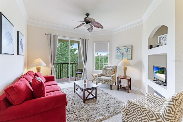 carpeted living room with ceiling fan and ornamental molding