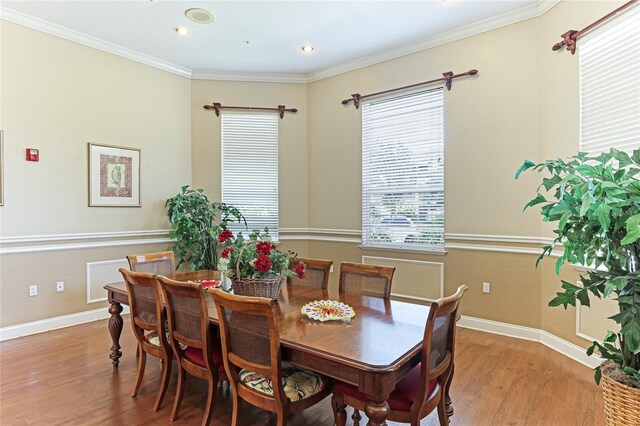 dining area featuring ornamental molding, a wealth of natural light, and hardwood / wood-style floors