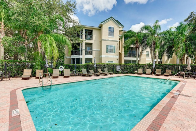 pool with a patio and fence