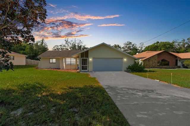 single story home with a garage and a yard