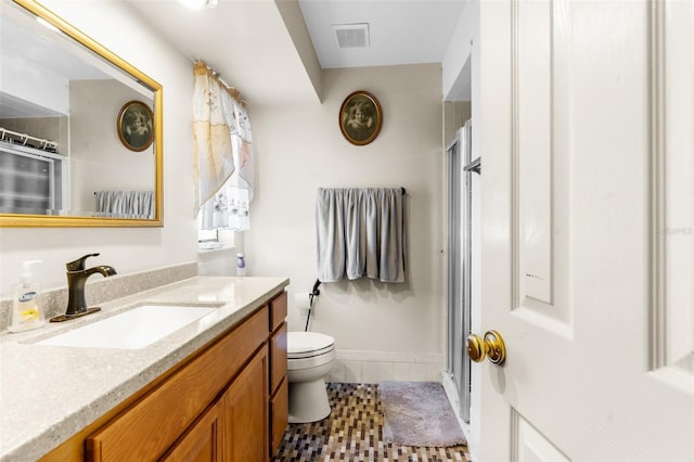 bathroom with tile patterned flooring, toilet, a shower with door, and vanity