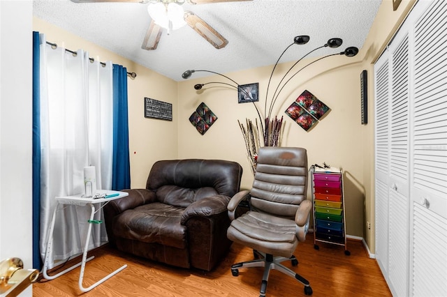 living area featuring a textured ceiling, ceiling fan, and hardwood / wood-style floors