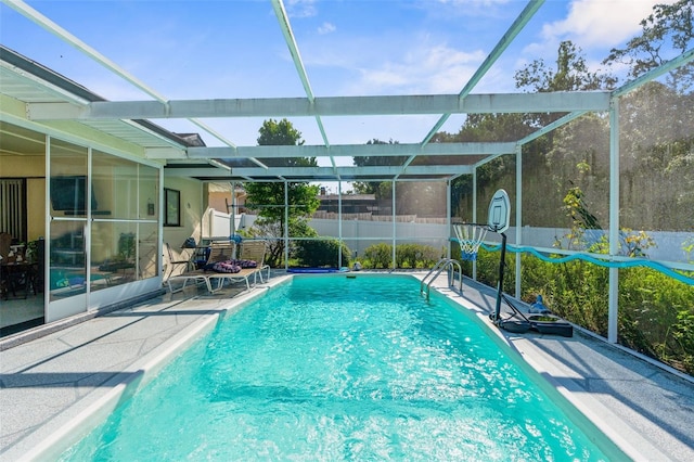 view of pool featuring a storage shed, glass enclosure, and a patio area