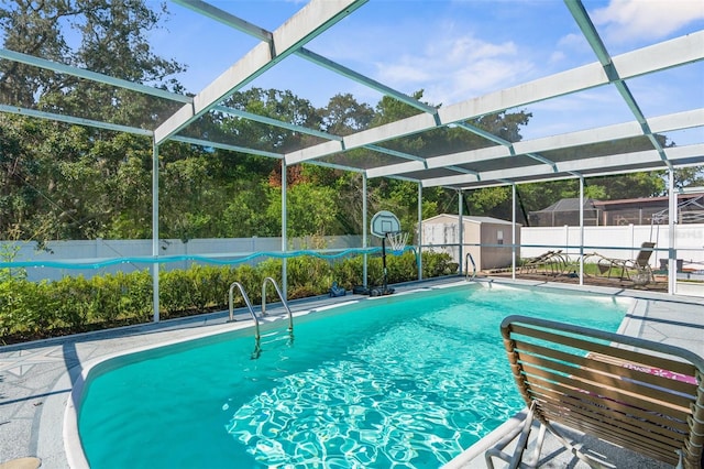 view of swimming pool featuring a lanai, a patio, and a storage shed