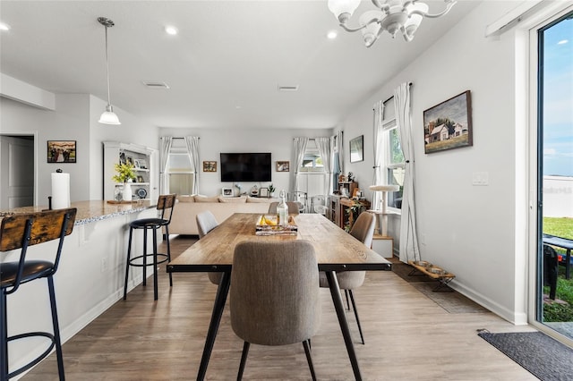 dining area featuring visible vents, an inviting chandelier, a healthy amount of sunlight, recessed lighting, and wood finished floors