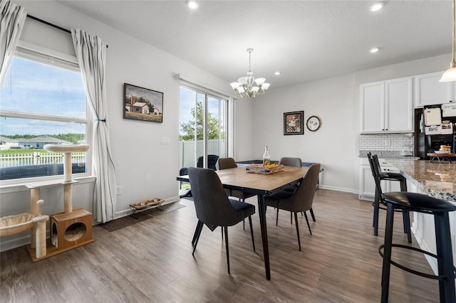 dining area featuring baseboards, recessed lighting, a chandelier, and wood finished floors