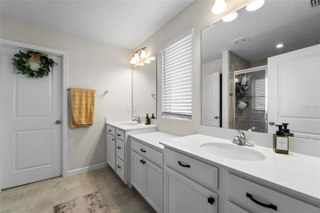 bathroom with two vanities, visible vents, a sink, and a stall shower