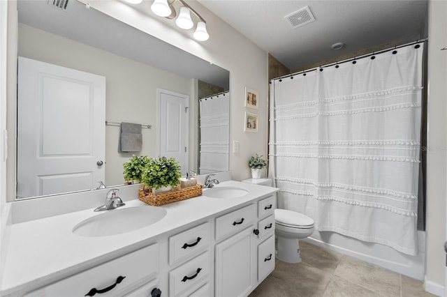 bathroom with double vanity, visible vents, a sink, and toilet