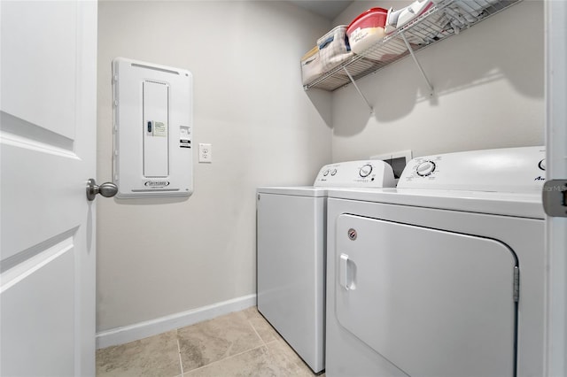 laundry area with baseboards, washing machine and dryer, laundry area, and electric panel