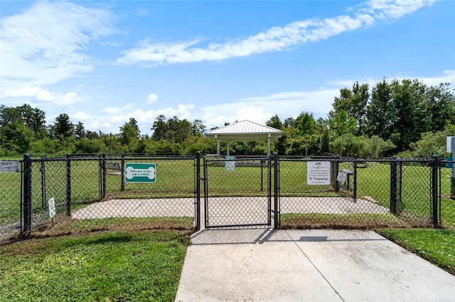 view of gate with a gazebo, fence, and a lawn