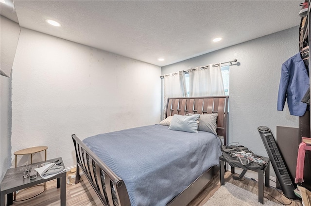 bedroom featuring a textured ceiling and light hardwood / wood-style floors