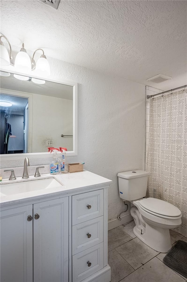 bathroom featuring a shower with shower curtain, tile patterned floors, toilet, vanity, and a textured ceiling