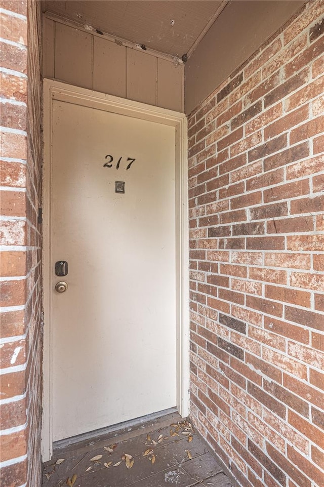 doorway to property featuring brick siding