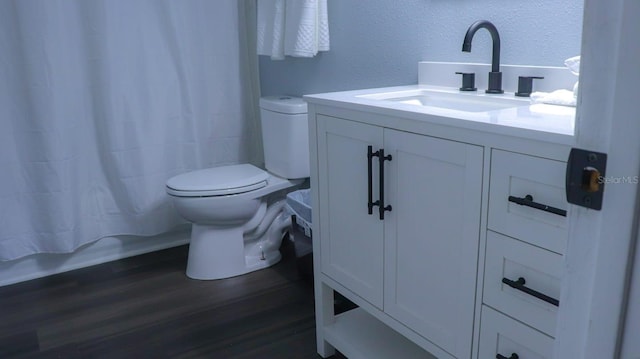 full bathroom featuring shower / tub combo with curtain, hardwood / wood-style floors, vanity, and toilet