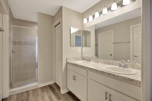 bathroom featuring hardwood / wood-style floors, an enclosed shower, and vanity