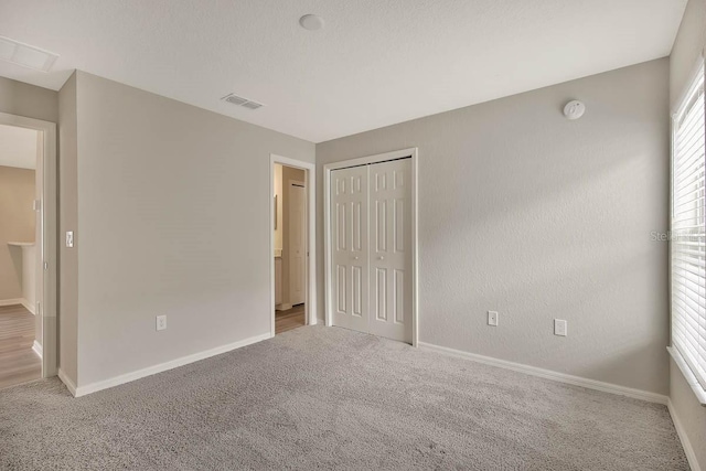 unfurnished bedroom featuring a closet and carpet floors