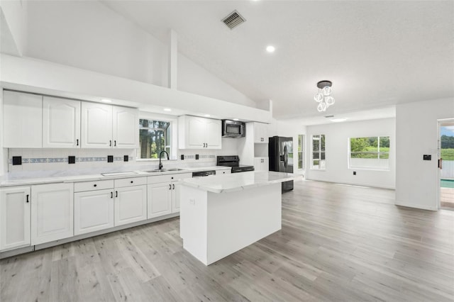 kitchen with white cabinetry, sink, decorative backsplash, and black appliances