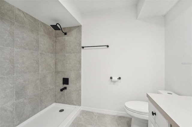 bathroom with tiled shower, vanity, toilet, and tile patterned floors