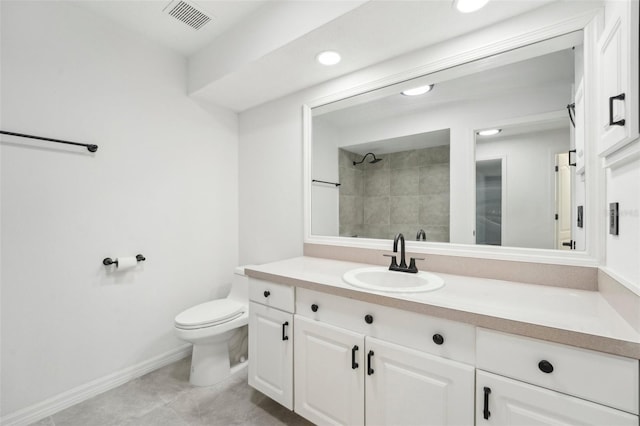 bathroom featuring tiled shower, vanity, and toilet