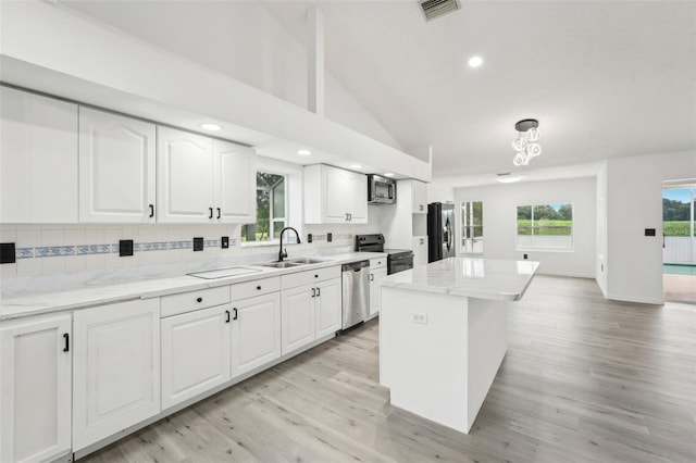 kitchen featuring sink, dishwasher, fridge with ice dispenser, white cabinets, and a kitchen island