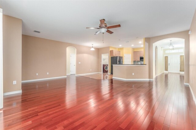 unfurnished living room with ceiling fan and wood-type flooring